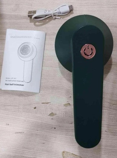 Electric Lint Remover with power symbol, USB cable, and instruction manual on a wooden surface
