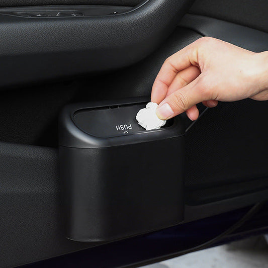Hand placing trash into a black car trash can with text on a dark background